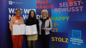 Laura Bischof (Mitte) mit ihren beiden Ausbilderinnen Regina Floderer (links) und Angela Jacobs (rechts) während des Festaktes für die besten Auszubildenden 2024 der IHK Ostthüringen am 8. November 2024