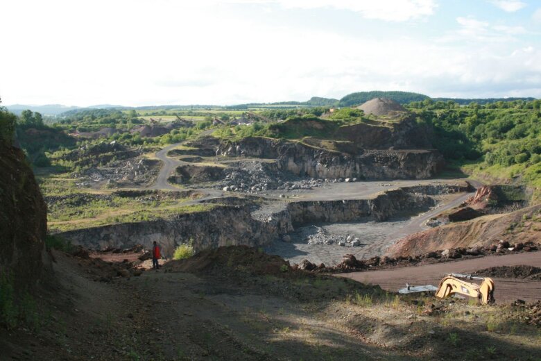 Blick in den nahezu vollständig abgebauten Wartgesberg-Vulkankomplex. Vor knapp 34 ka bildeten sich nahezu zeitgleich mehrere Eruptionszentren an der Ostflanke des Alfbachtals. Die geförderten Schlacken, Agglutinate und Laven türmten sich zu einer bis zu 80 m hohen Barriere auf und führten die vollständige Abriegelung des Tals herbei