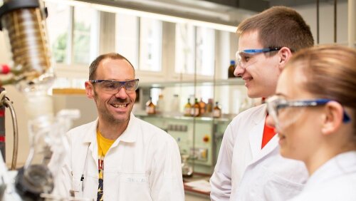 Ein Dozent und zwei Studierende während eines Laborpraktikums Chemie an der Universität Jena.
